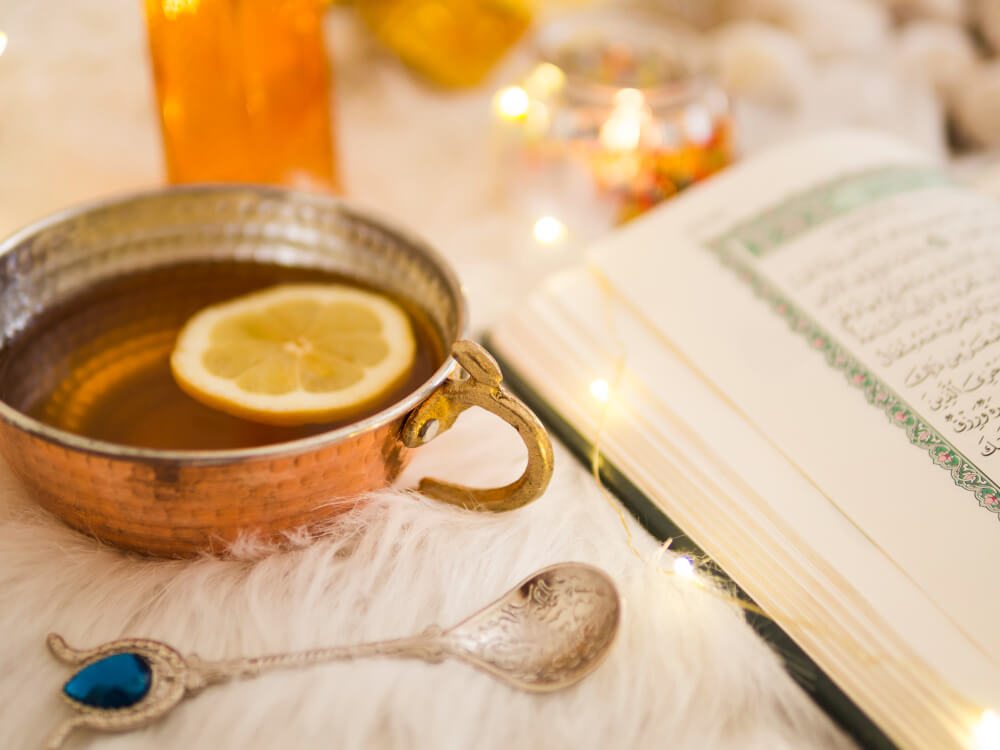 A Quranic book placed beside a bowl of water, symbolizing the benefits of reciting Quranic verses